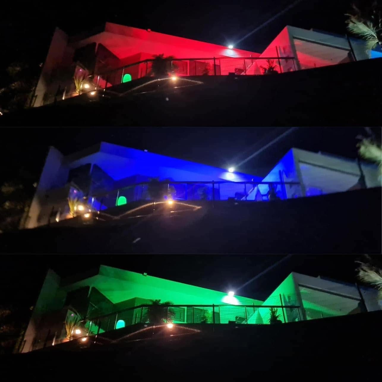Façade de maison éclairée la nuit en rouge, bleu et vert